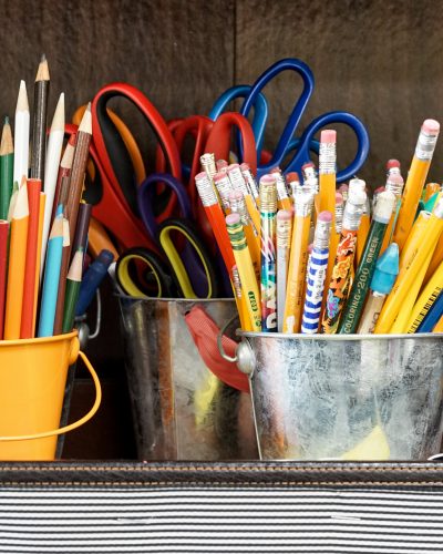 כלי כתיבה (עפרונות ומספריים) מאורגנים בדליים ממתכת